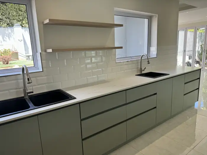 The kitchen run and sinks set along the window wall