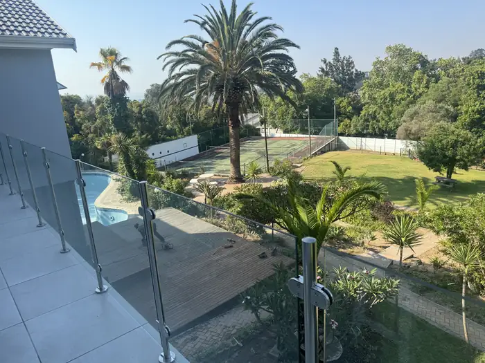 The pool and garden seen from the balcony over the frameless glass