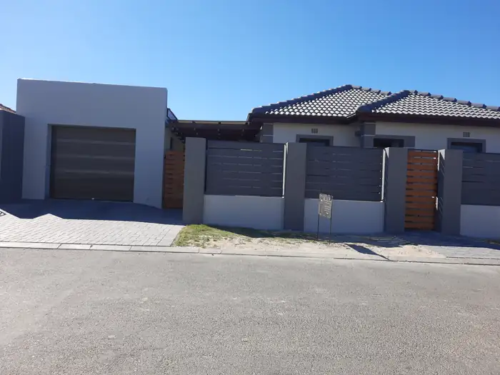 The street frontage of House Canham with the garage and boundary screens