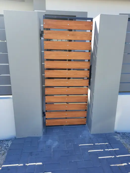 The timber pedestrian gate between its plastered piers