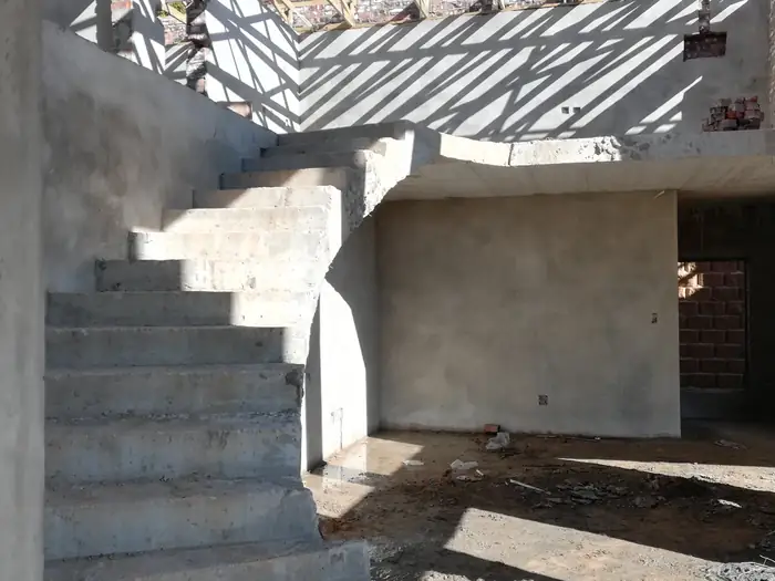 The custom curved concrete staircase at House Chapman, cast on site
