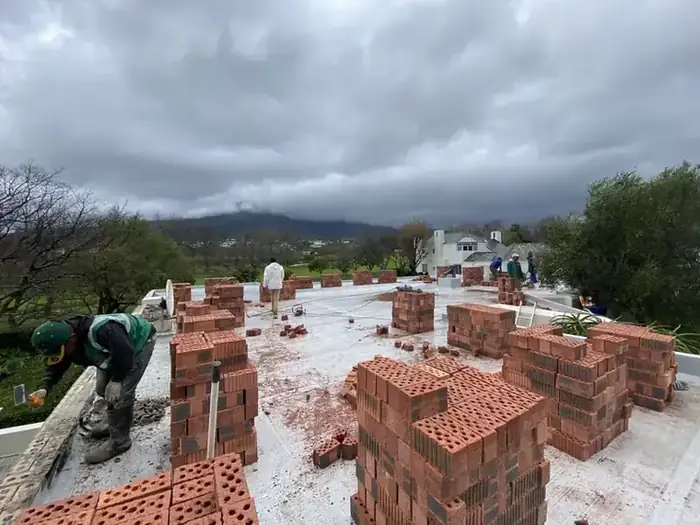 Brick stacked on the new slab, ready for the walls to go up