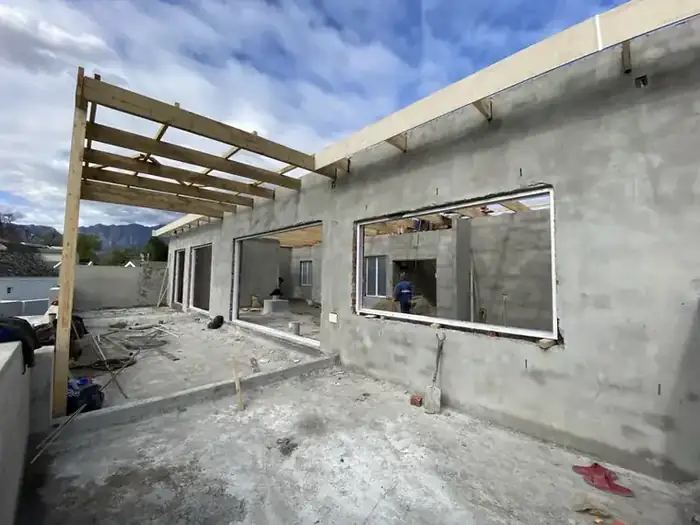 Plastered walls and roof timbers going on over the new floor