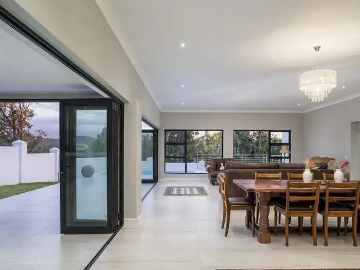 The finished living and dining area at House Hillcrest with stacker doors open to the terrace