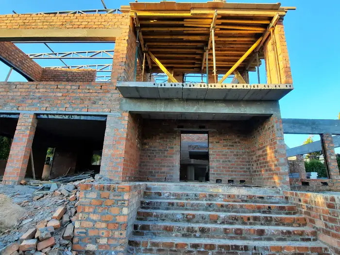 The roof structure going up over House Hillcrest at dusk