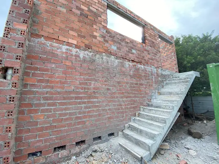 The cast concrete external staircase against the brickwork before plaster