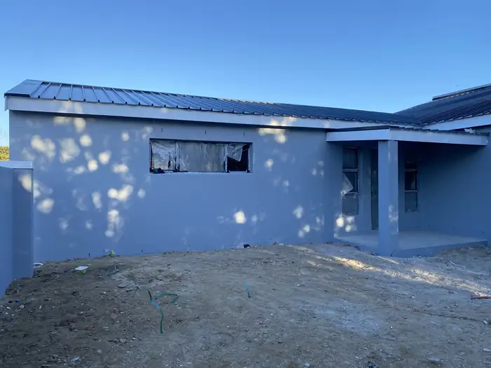 The house painted and under roof, photographed before the aluminium went into the openings