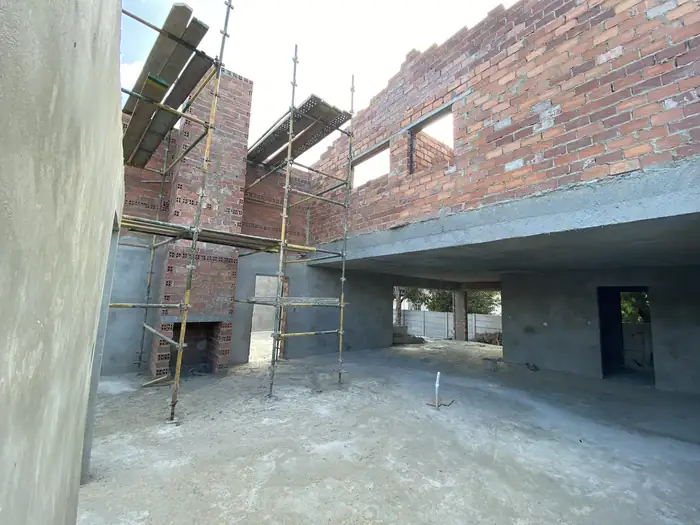 Scaffolding up against the brickwork with plastering under way