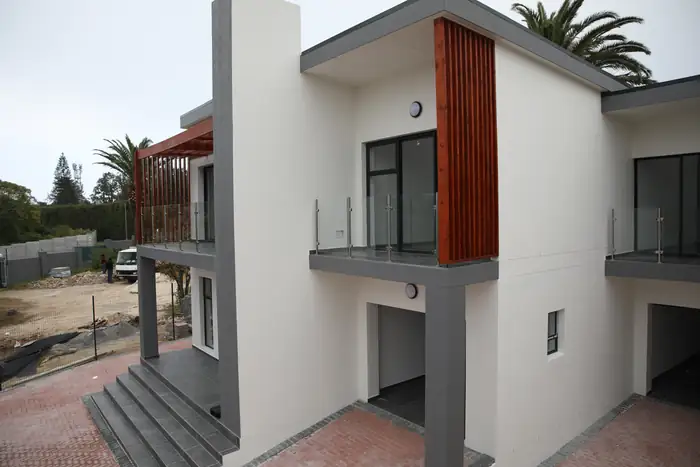 A vertical timber screen on the balcony corner with the parking bay underneath