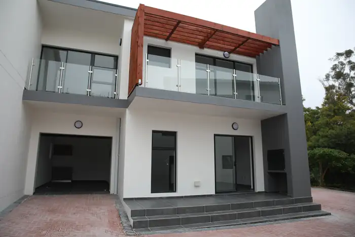 Balcony, glass balustrade and timber screen on a finished house
