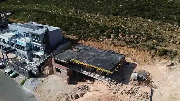 The structure sitting in the cut, with the slope rising behind it