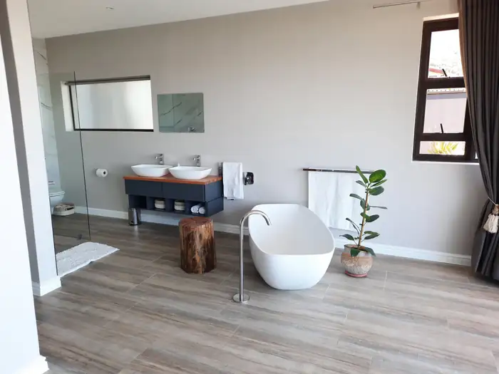 A freestanding bath and twin vanity open to the bedroom